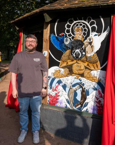 Artist, Scott, standing beside his work 