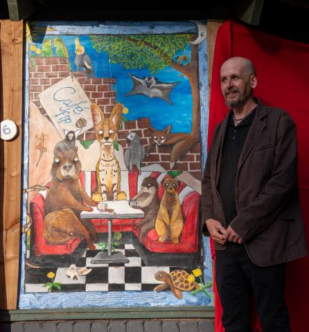 Phil, an artist standing beside his work 